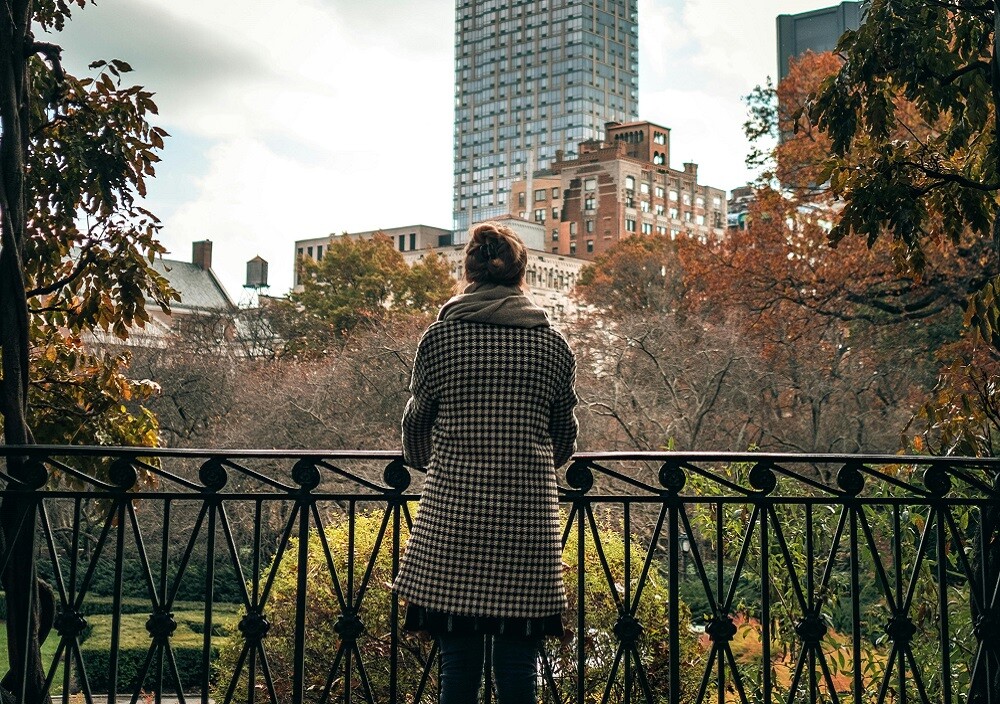 Vrouw kijkt via het park naar gebouwen