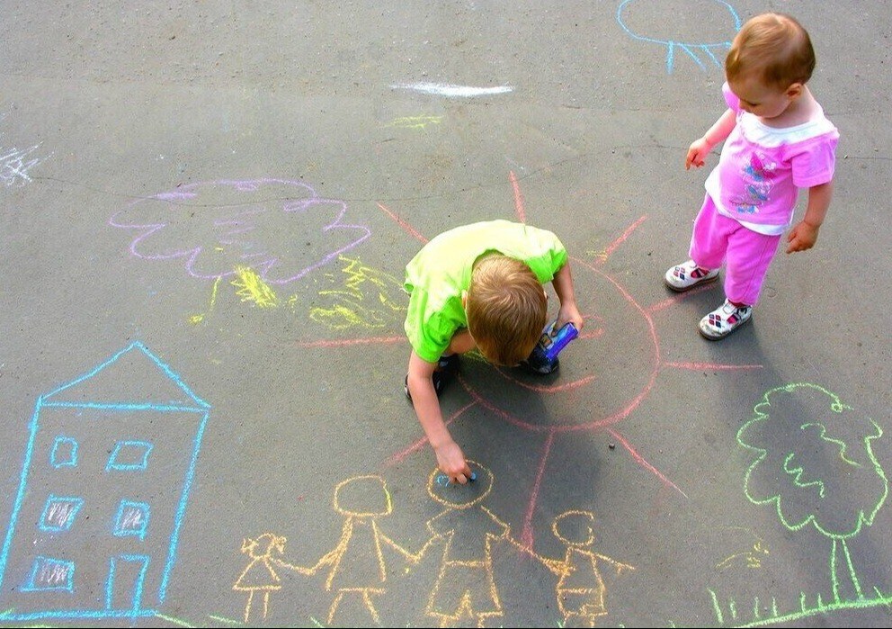 Kinderen maken een krijttekening van een dorp